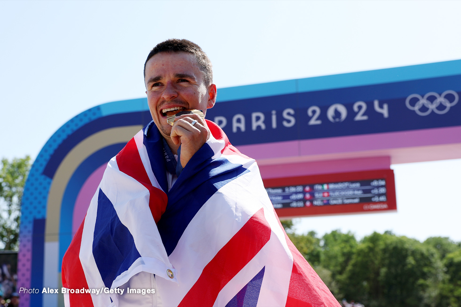 ELANCOURT, FRANCE - JULY 29: Gold medalist Thomas Pidcock of Team Great Britain bites his medal during the Men's Cross-Country on day three of the Olympic Games Paris 2024 at Elancourt Hill on July 29, 2024 in Elancourt, France. (Photo by Alex Broadway/Getty Images)