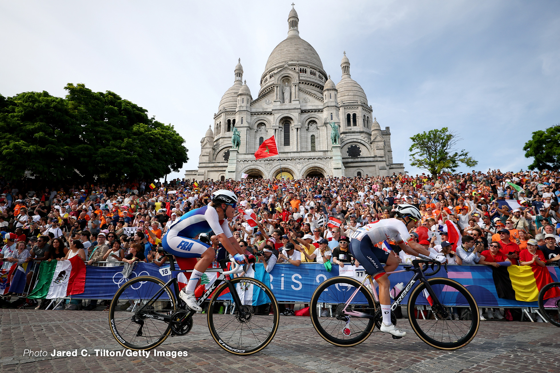 PARIS, FRANCE - AUGUST 04: (L-R) Victoire Berteau of Team France and Eri Yonamine of Team Japan compete passing by the Basilica of the Sacre Coeur while fans cheers during the Women's Road Race on day nine of the Olympic Games Paris 2024 at Trocadero on August 04, 2024 in Paris, France. (Photo by Jared C. Tilton/Getty Images)